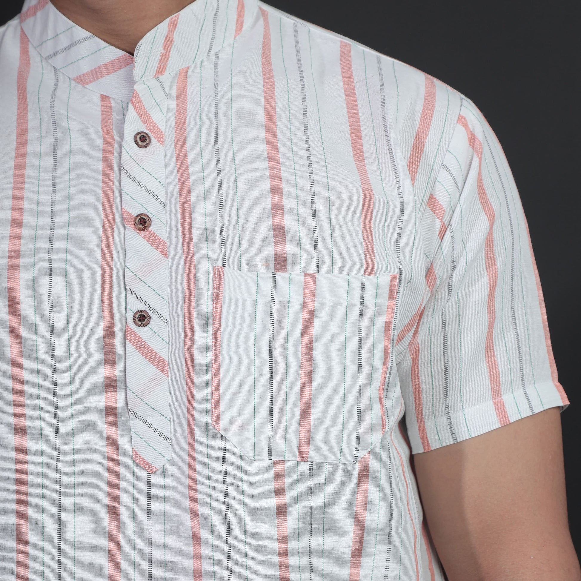 Close-up of white kurta with orange stripe pattern and pocket detail