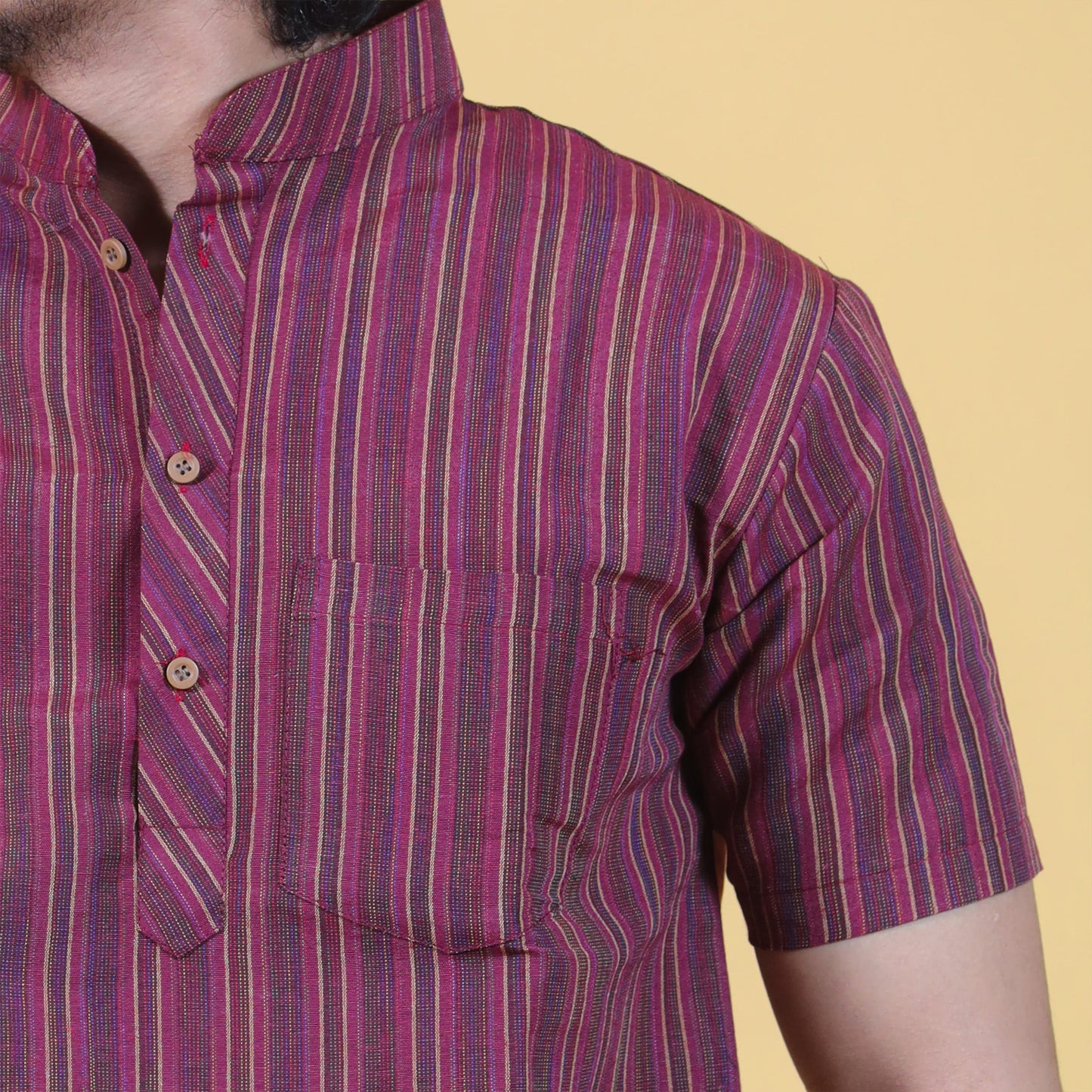 Close-up of maroon striped khadi fabric texture and button placket detail