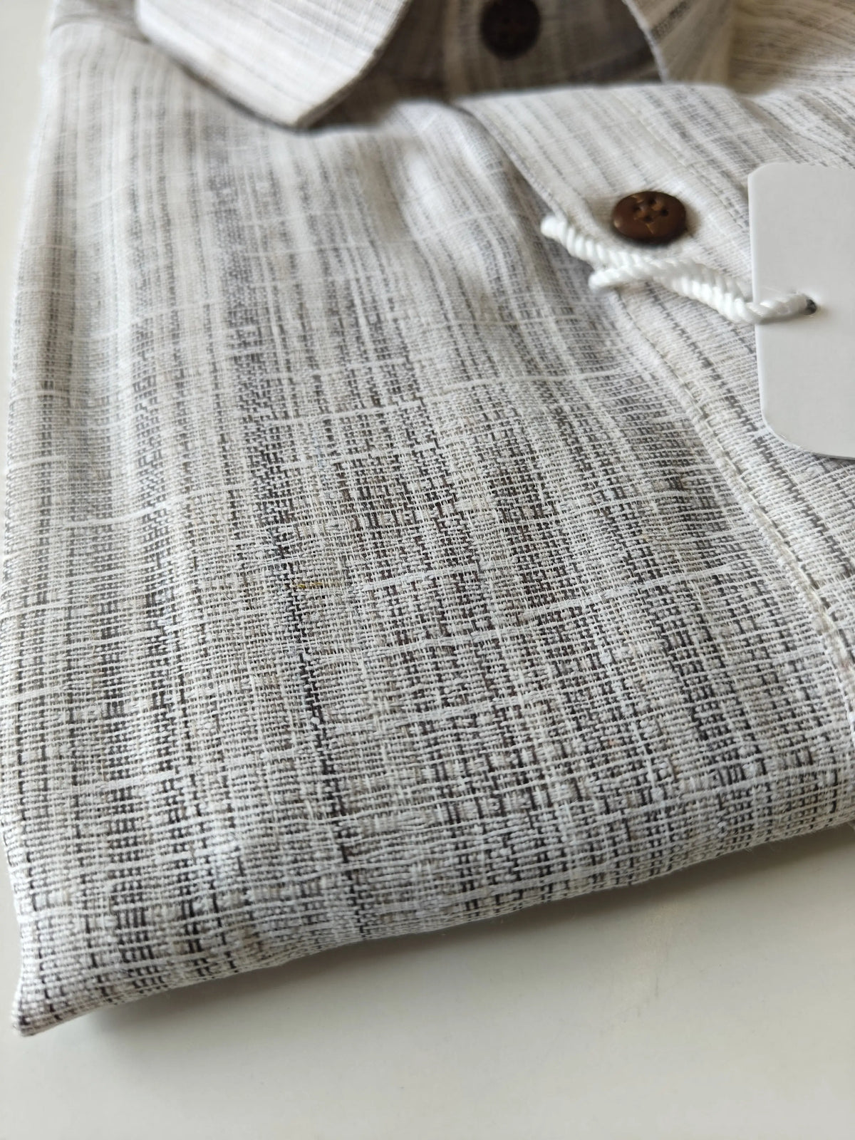 Close-up of grey handloom cotton shirt texture with front button detail