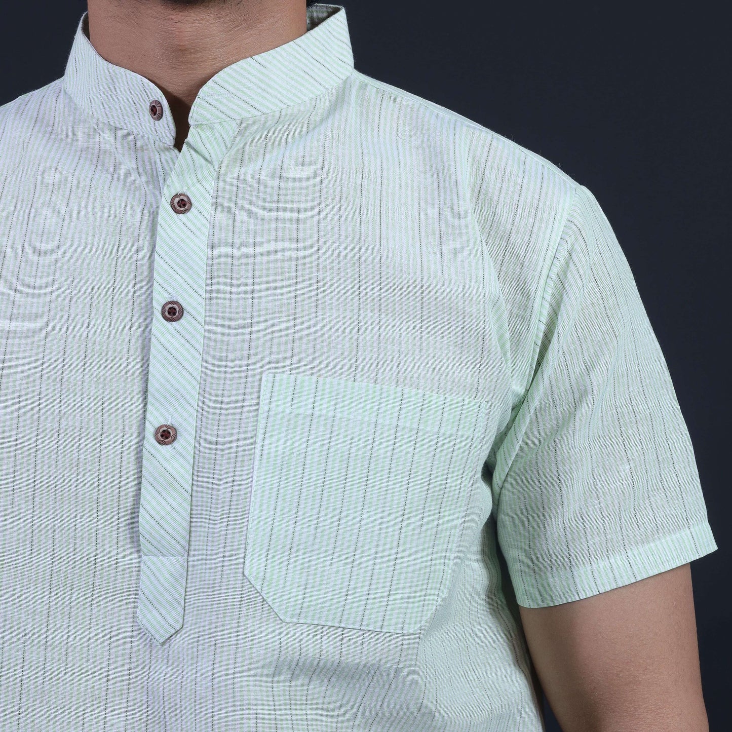 Close-up of green loomstripe half sleeves khadi kurta with mandarin collar and pocket detailing