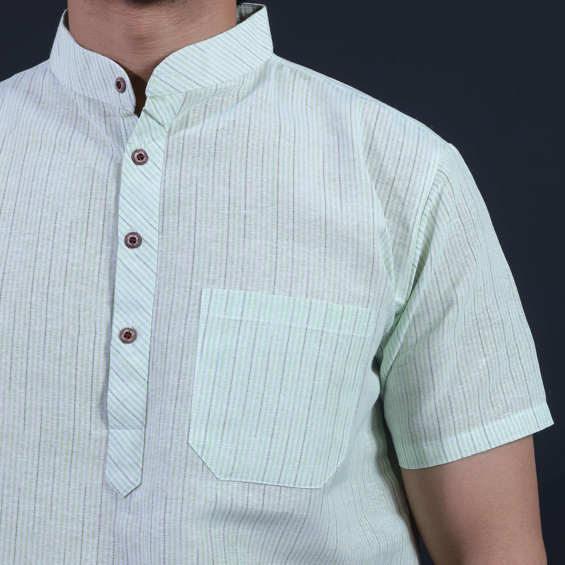 Close-up of green loomstripe half sleeves khadi kurta with mandarin collar and pocket detailing