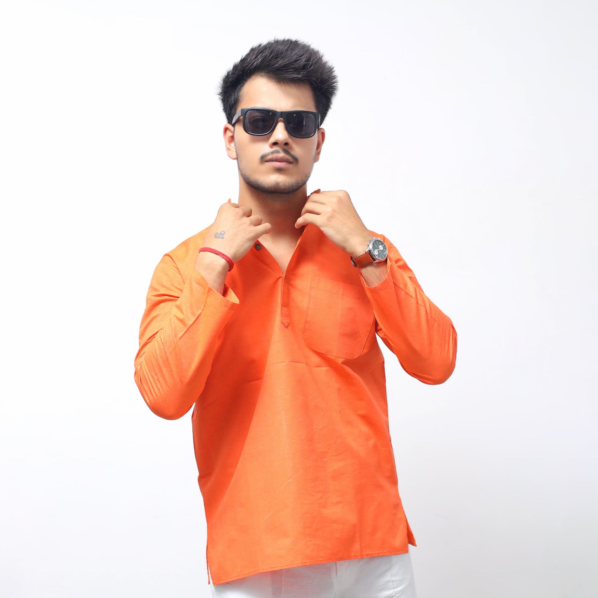 Men wearing orange khadi cotton short kurta adjusting sleeve stylish look