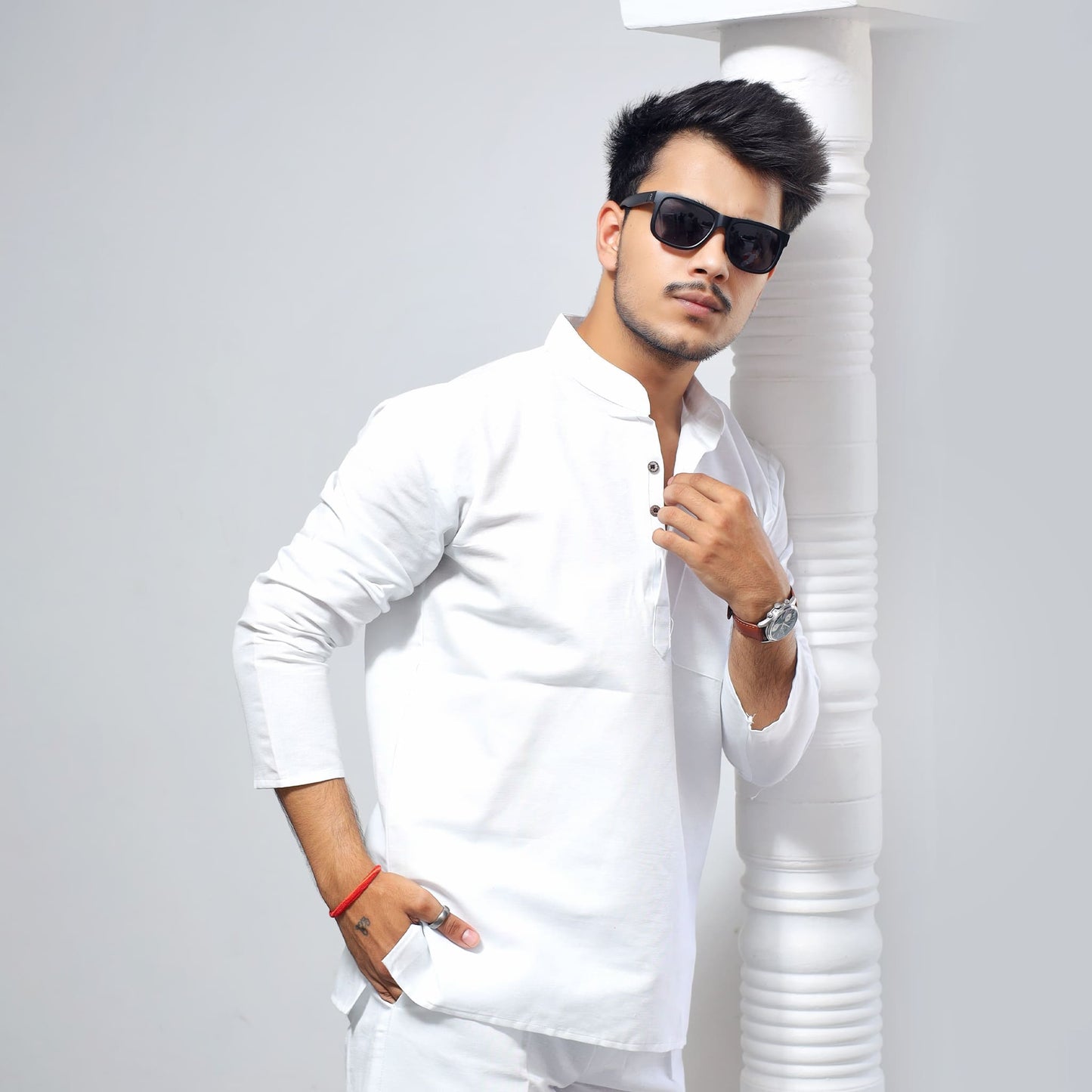 White Solid Full Sleeves Khadi Cotton Short Kurta styled look with model leaning near pillar