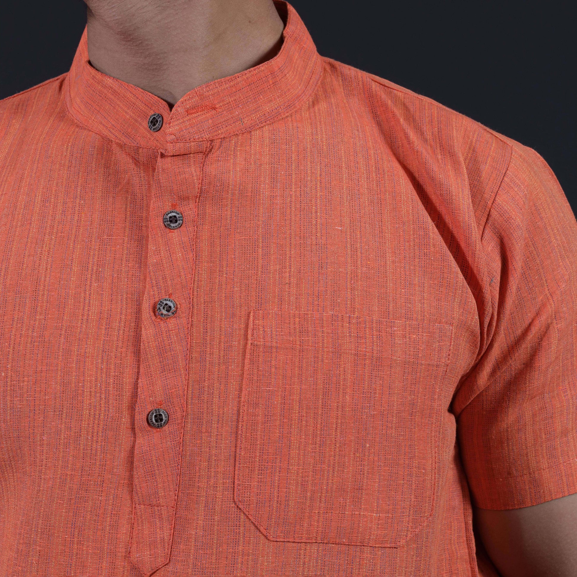 Close-up of orange khadi kurta showing thread line texture mandarin collar and chest pocket