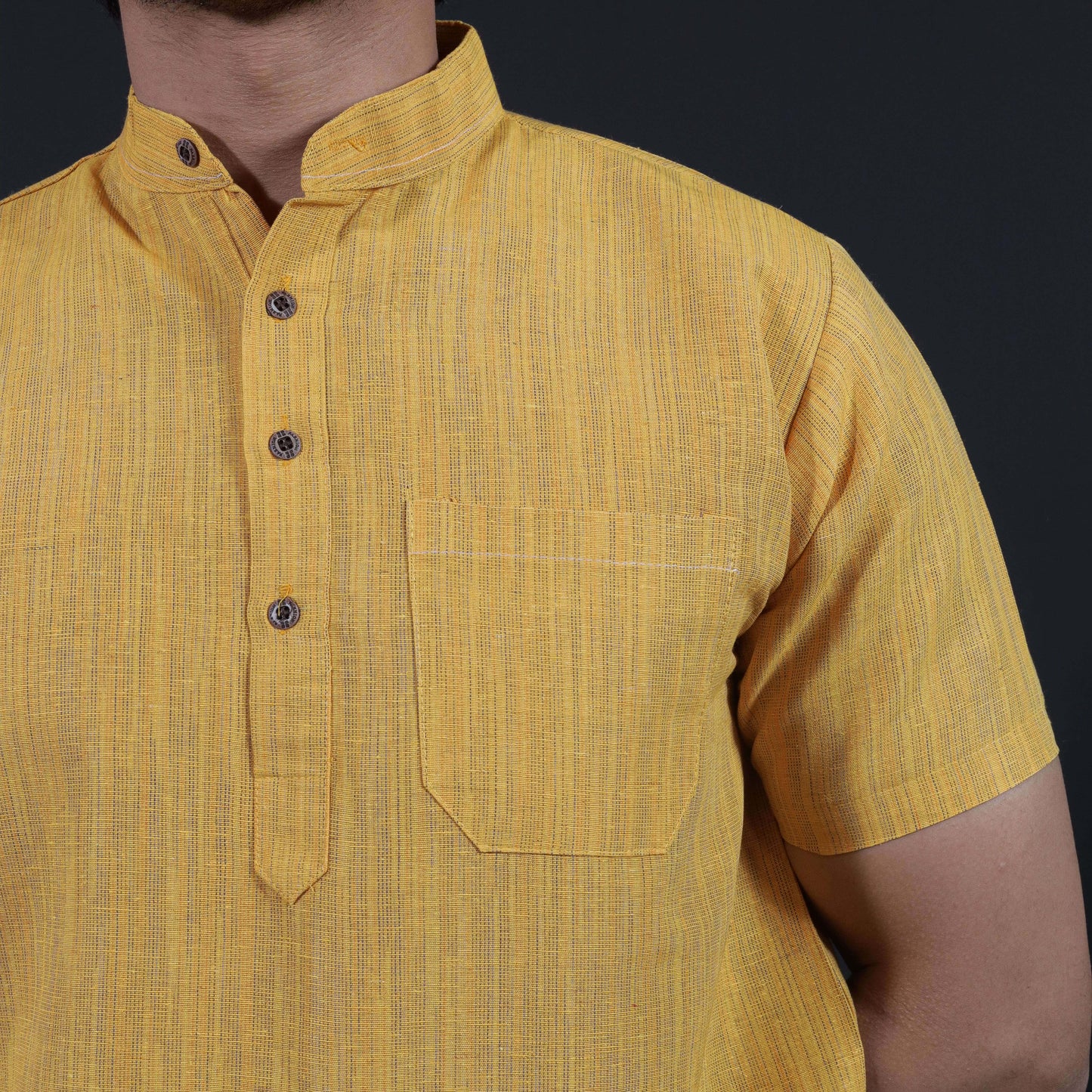 Close-up of yellow khadi kurta with fine thread lines texture
